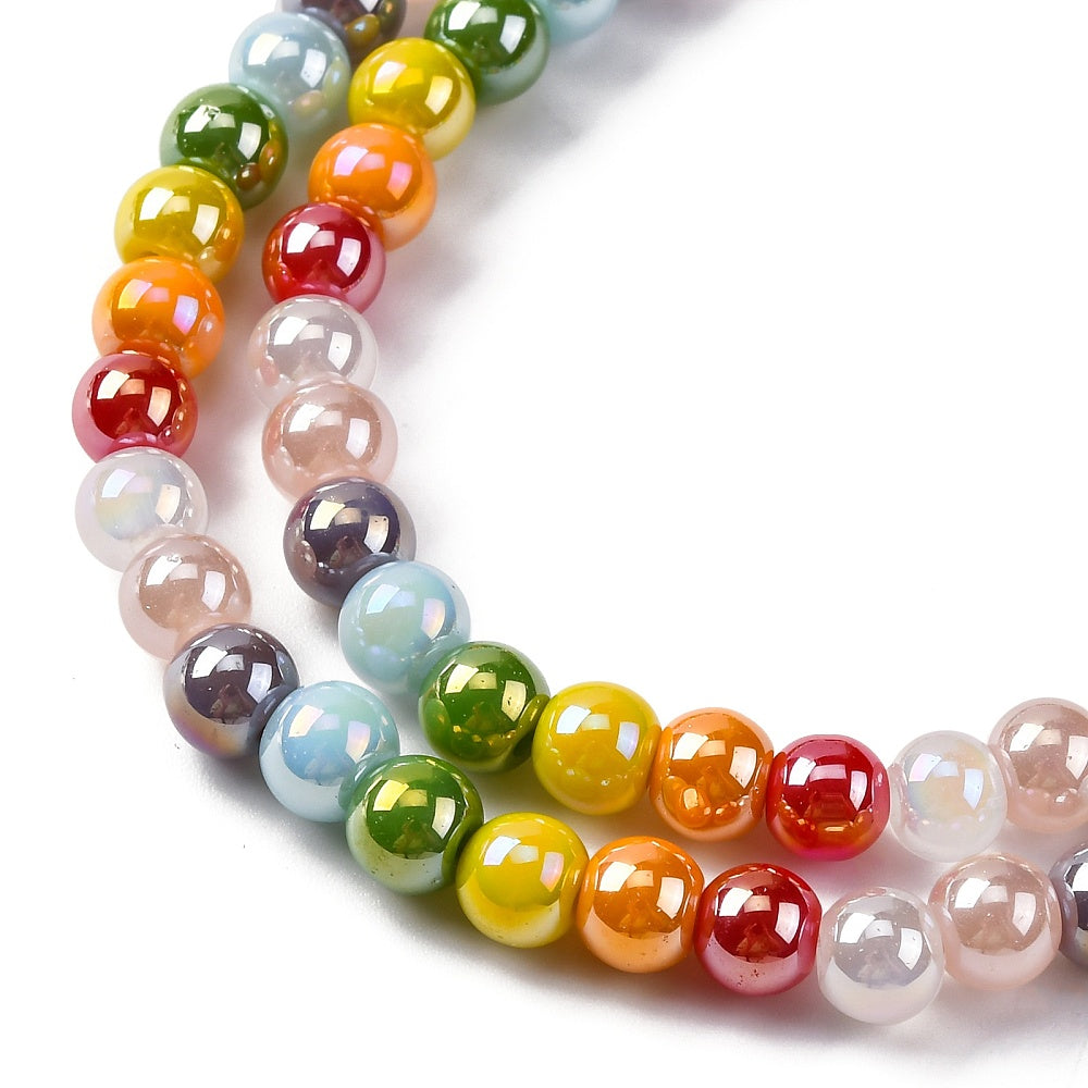 zoomed in sections of iridescent opaque rainbow glass bead strand over white surface. 
