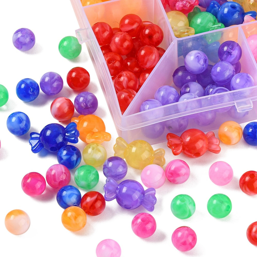zoomed in bottom corner of box containing beads with beads spilled around the base of the box on a white surface. 