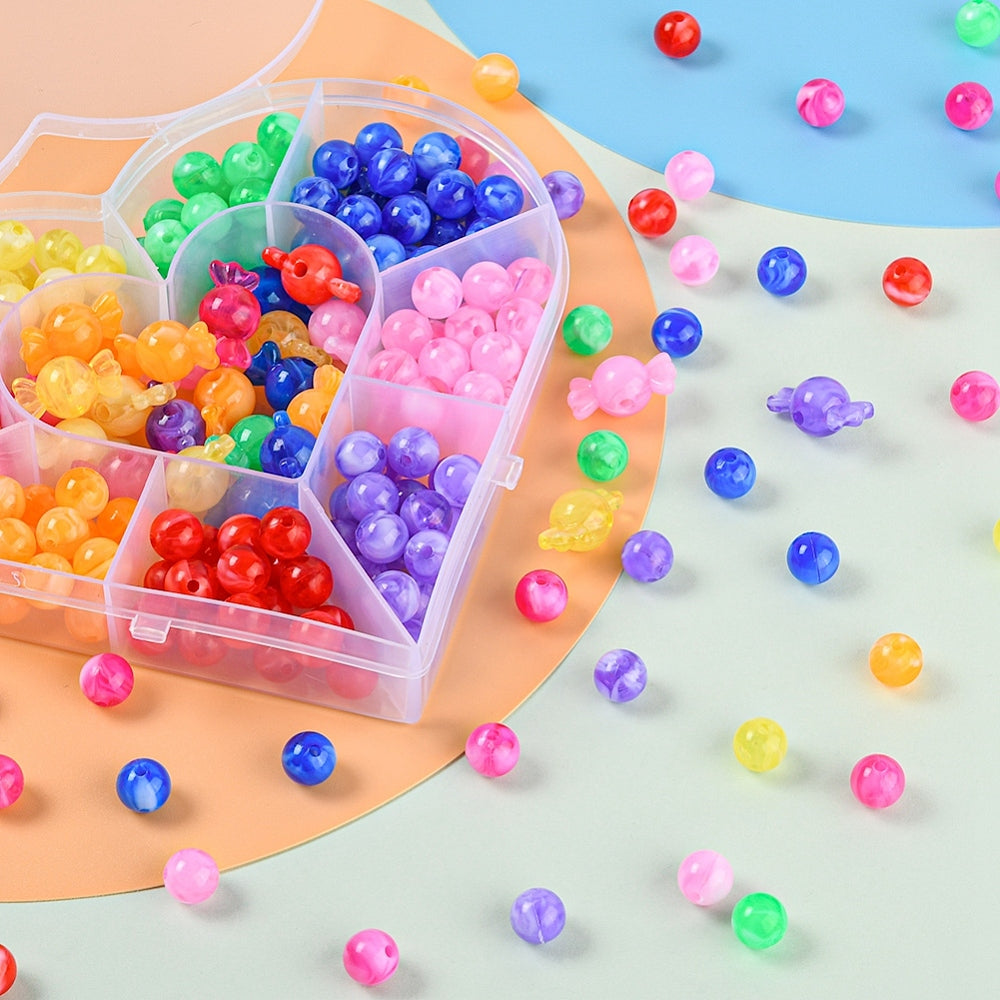 portion of shaped bead box with beads spilled around the base of the box on a multi-colored surface. 