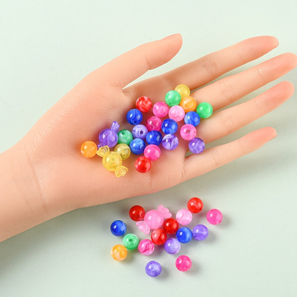 sample of each color and shape of beads contained in a kit displayed on a mannequin hand and on a mint green surface. 