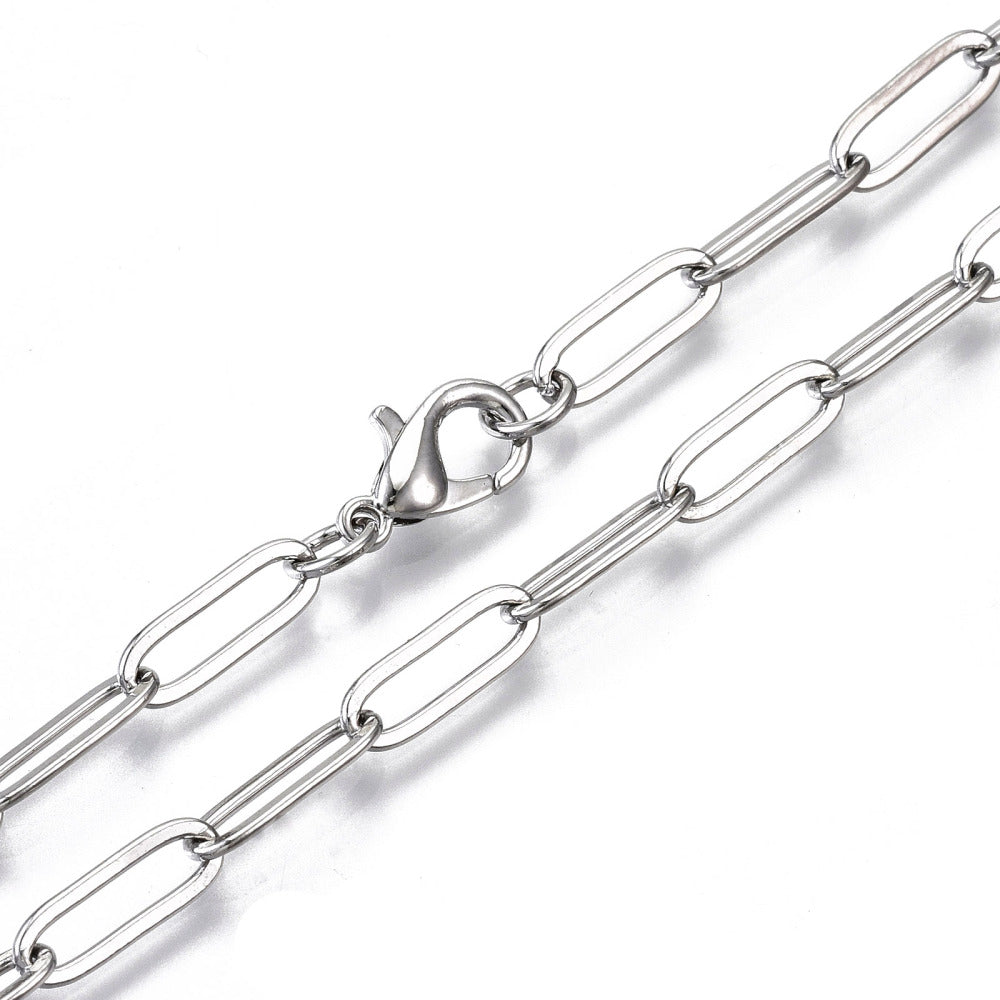 zoomed in section of silver tone large paperclip link chain with lobster claw clasp on white background. 