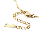 zoomed in section of golden wave bar link chain necklace with lobster claw clasp and extender chain over white surface. 