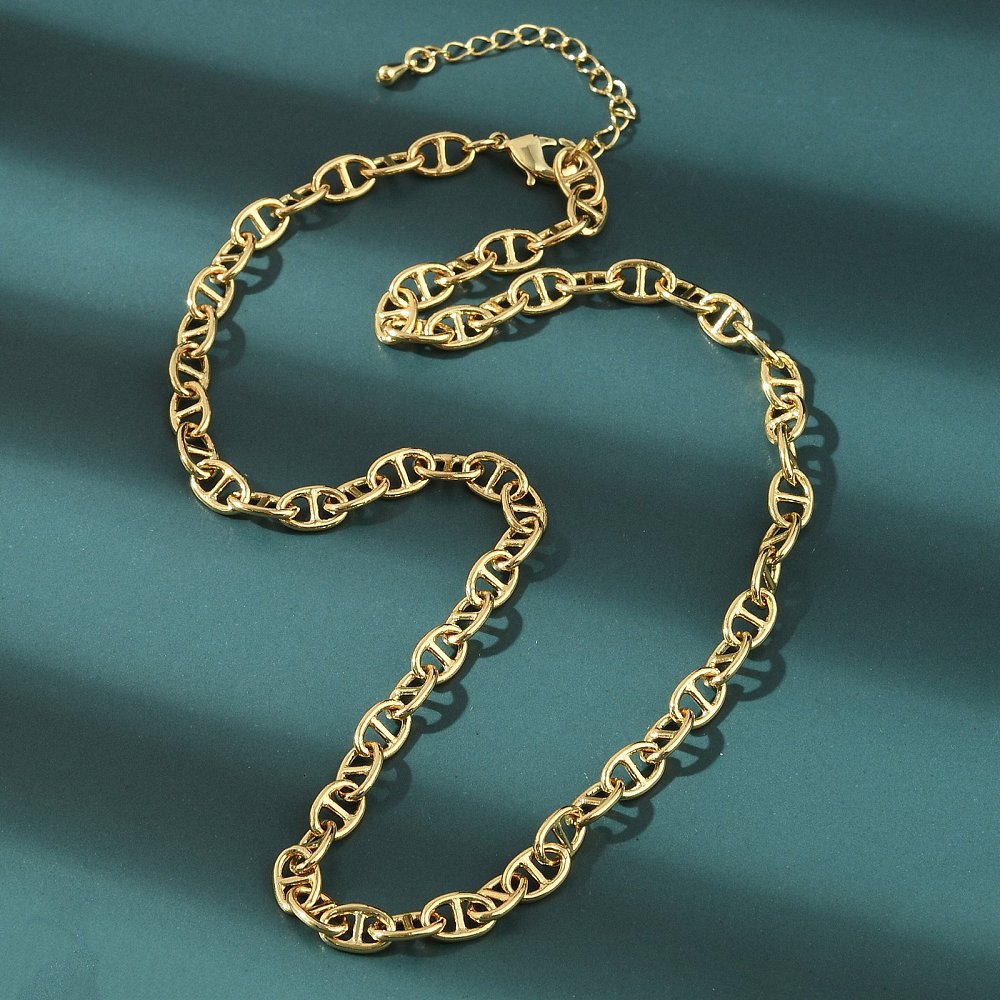 golden oval mariner link chain necklace with lobster claw clasp and extender chain over green felt background. 