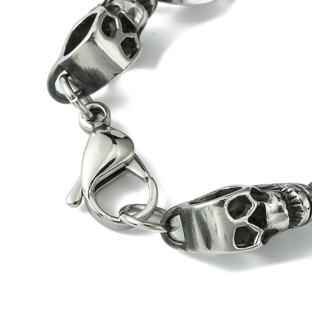 zoomed in section of lobster claw clasp on skull link chain on white background. 