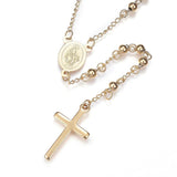 golden beaded Rosary with front of miraculous medal and cross pendant over white background. 