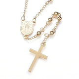 golden beaded Rosary with back of miraculous medal and cross pendant over white background. 