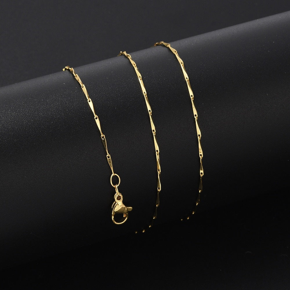golden twisted bar link necklace with lobster claw clasp wrapped around black cylinder on black background.