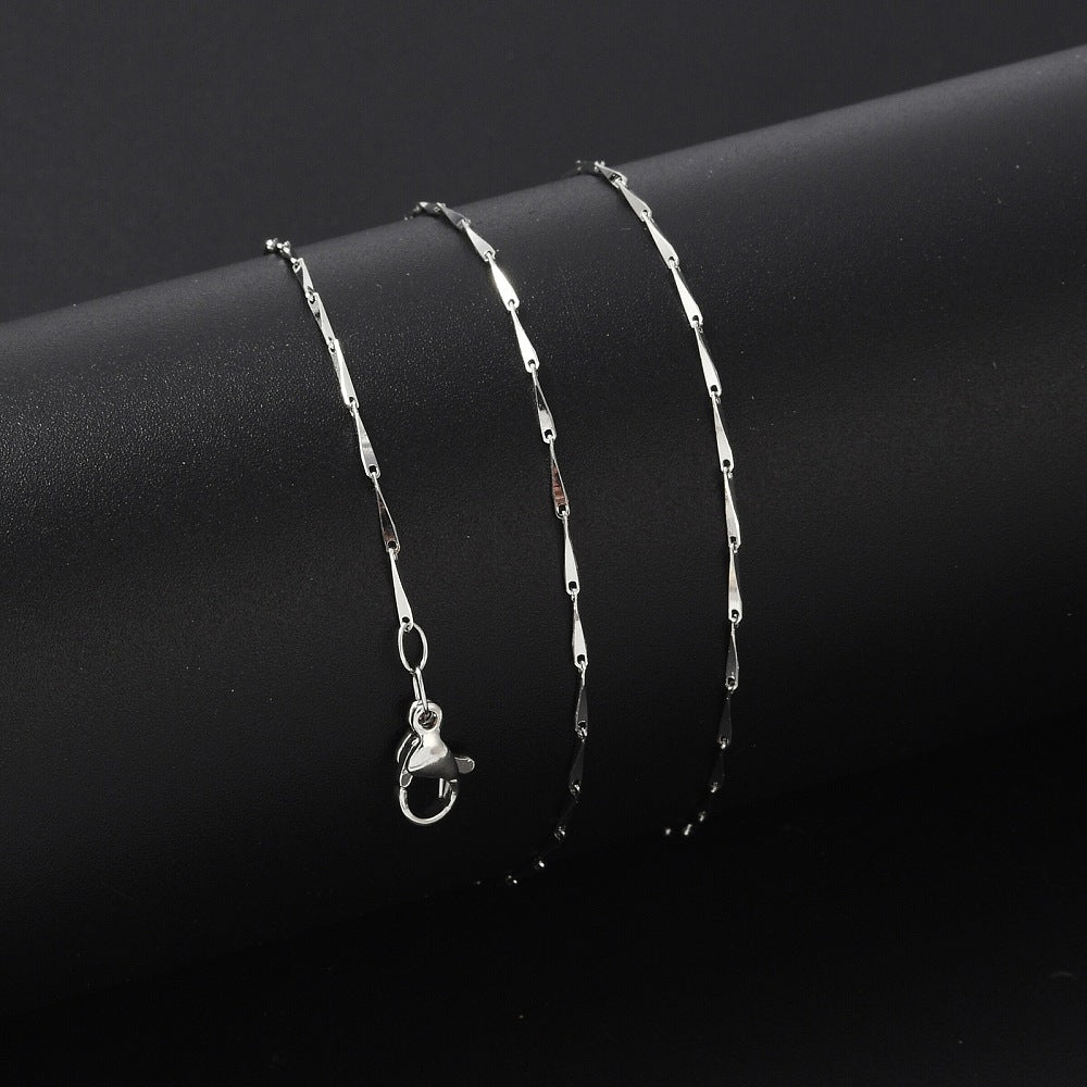silver tone twisted bar link necklace with lobster claw clasp wrapped around black cylinder on black background.