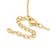 zoomed in golden lobster claw clasp with extender chain over white surface. 
