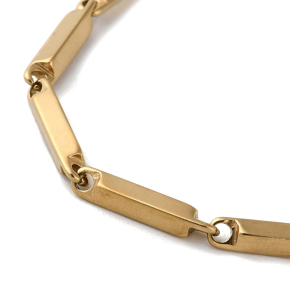 zoomed in section of golden bar link chain over white background. 