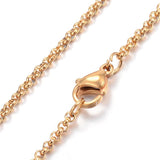 zoomed in sections of golden Rolo chain necklace with lobster claw clasp over white background. 