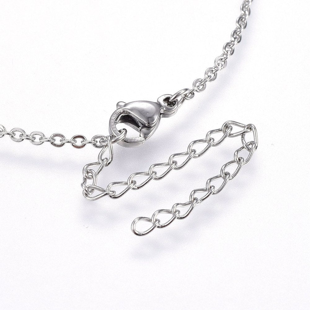 zoomed in silver tone lobster claw clasp and extender chain on cable chain necklace over white surface. 