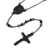 zoomed in front of black oval medal connector and crucifix over white background. 