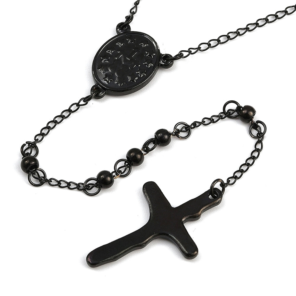 zoomed in back of black oval medal connector and crucifix over white background. 