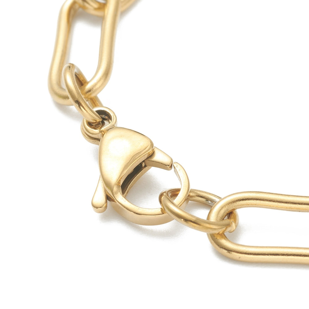 zoomed in section of golden large round paperclip chain necklace with large lobster claw clasp over white background. 