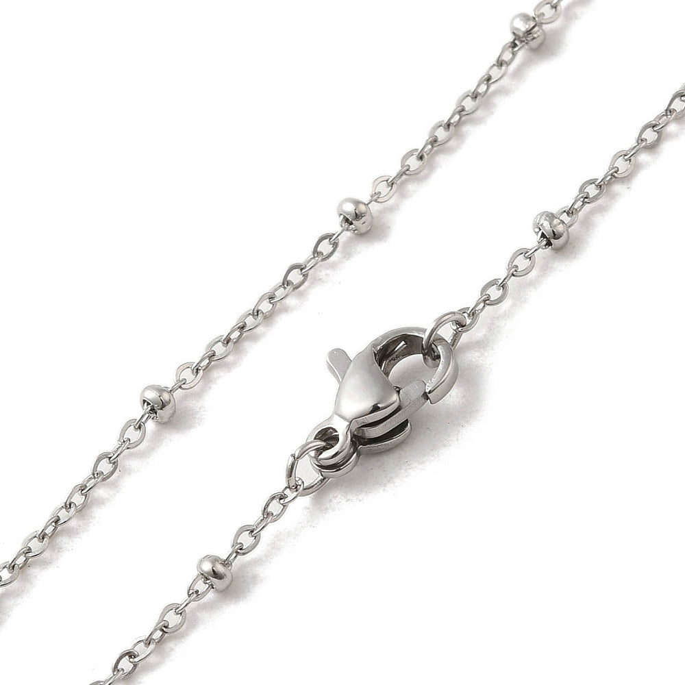 zoomed in sections of silver tone satellite chain necklace with rondelle beads and lobster claw clasp over white background. 