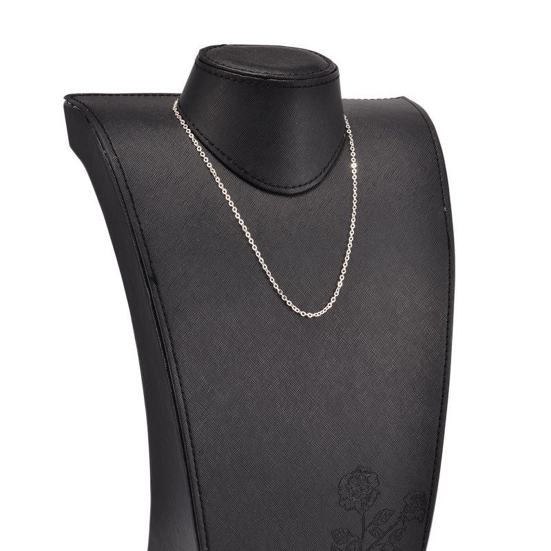 silver tone cable chain displayed on black neck form against white background. 