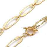 zoomed in sections of golden safety pin link chain necklace with toggle clasp over white background. 