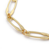 zoomed in section of golden safety pin link chain over white background. 