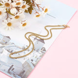 golden small curb chain with lobster claw clasp over photo of Greece on pink surface with daisy flowers in the corner. 