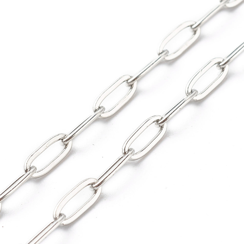 zoomed in sections of silver tone paperclip chain necklace over white background. 