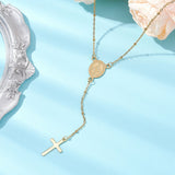 golden satellite chain rosary style necklace with Virgin Mary connector and cross pendant draped over a pale peach rose onto a light blue background. 