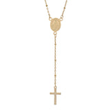 zoomed in section of golden satellite chain rosary style necklace with Virgin Mary connector and cross pendant over white background. 