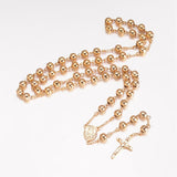 golden large bead rosary necklace with oval medal connector and crucifix pendant over white background.  