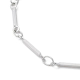 zoomed in section of silver tone bar link chain necklace over white background. 