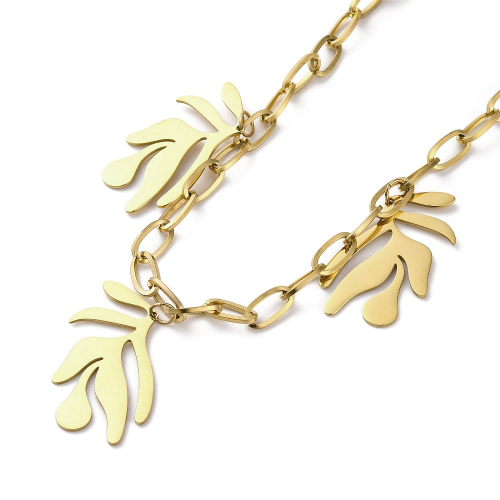 zoomed in section of golden paperclip chain necklace with three leaf design drops over white surface. 