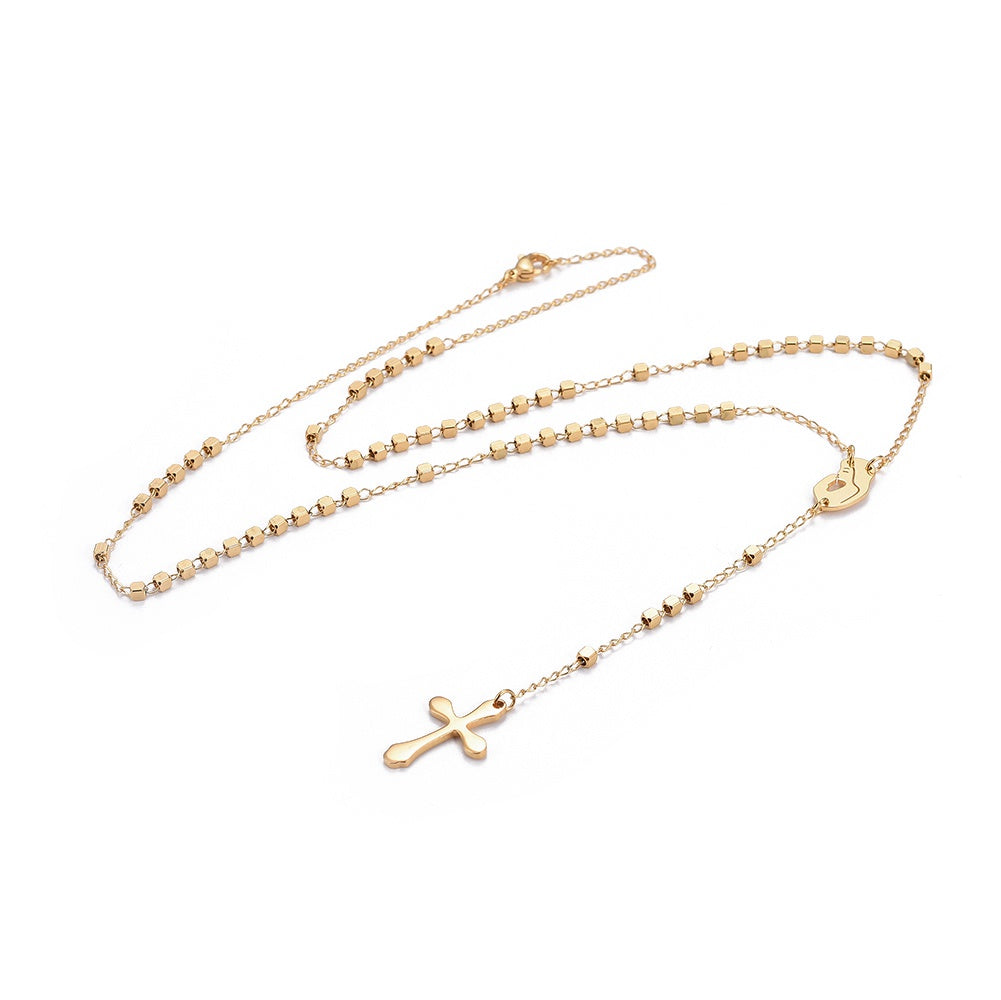 golden rosary necklace with cube rosary beads a profile of Virgin Mary connector a cross pendant with a lobster claw clasp over white background. 