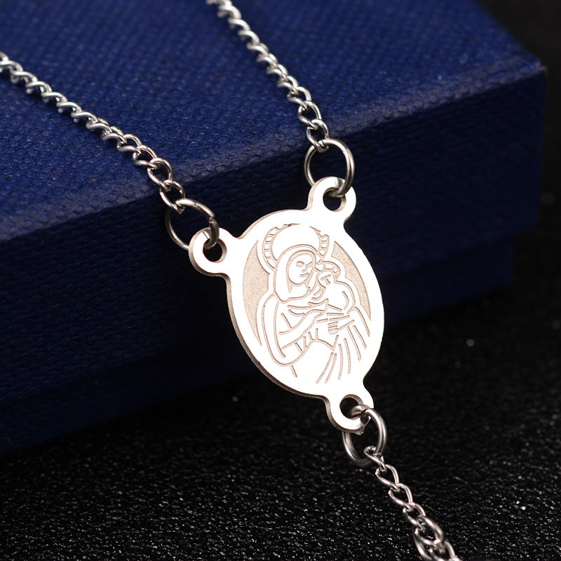 zoomed in front of silver oval medal connector piece draped over blue box onto black surface. 