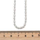 silver tone oval and round link ball chain necklace displayed over wooden ruler with white background. 
