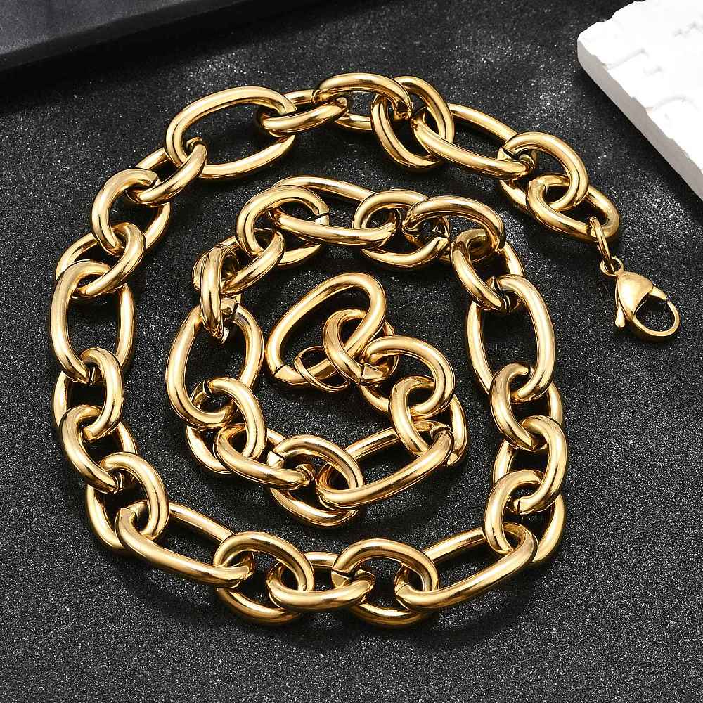golden, large alternating oval and round link chain necklace with lobster claw clasp on textured black background. 