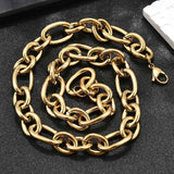golden, large alternating oval and round link chain necklace with lobster claw clasp on textured black background. 
