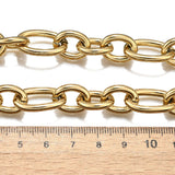golden, large alternating oval and round link chain displayed above wooden ruler  on white background. 