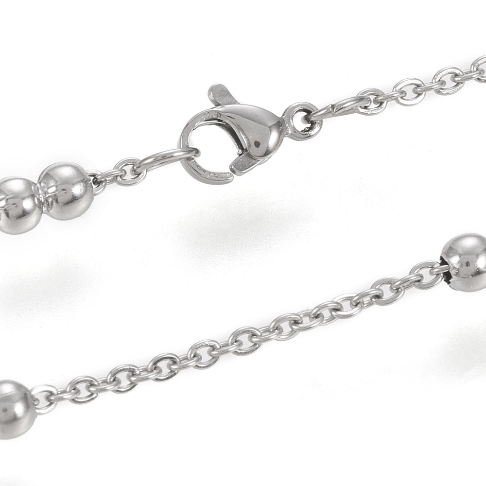 zoomed in sections of silver tone cable link double satellite chain necklace with lobster claw clasp on a white background. 