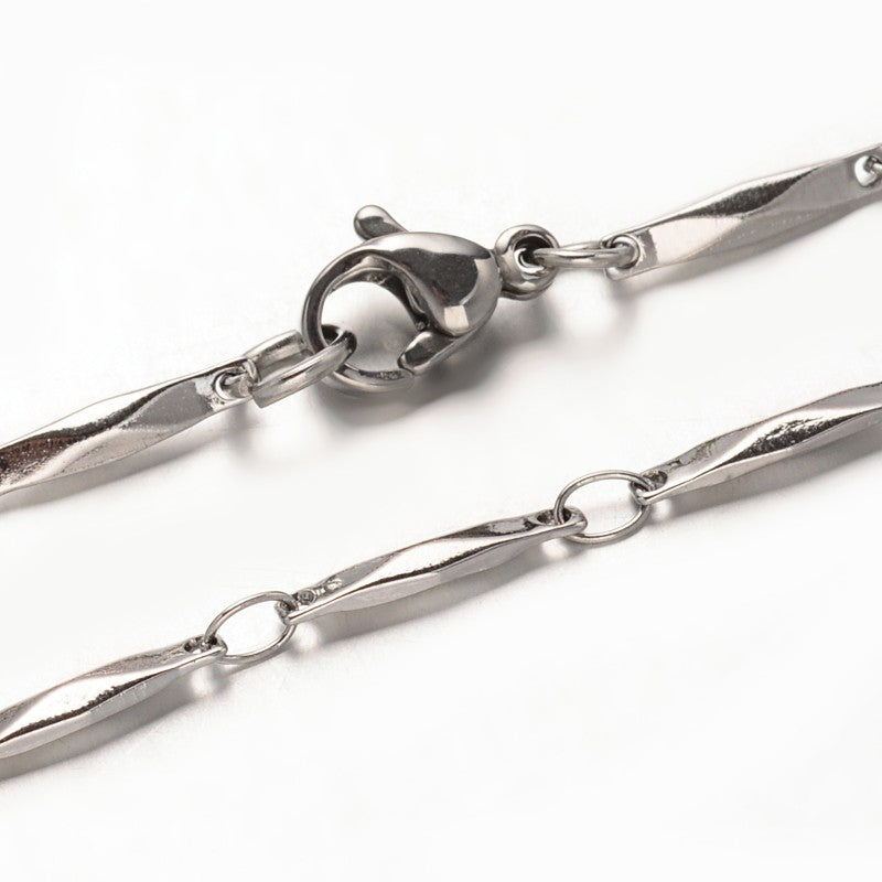 zoomed in sections of silver tone bar link necklace with lobster claw clasp over white background. 