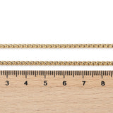 golden Venetian box chain displayed above wooden ruler on white background. 