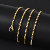 golden Venetian box chain with lobster claw clasp wrapped around a black cylinder on black background. 