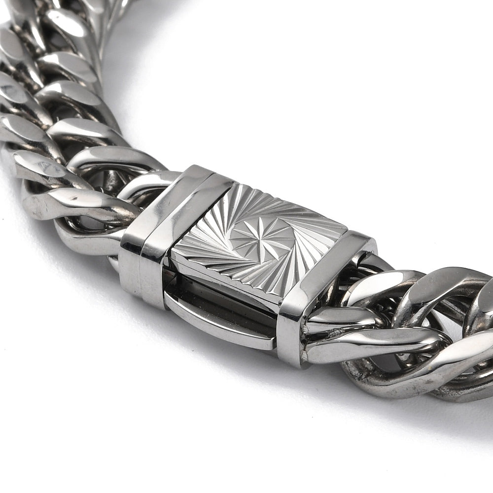zoomed in section of silver tone extra large curb link necklace with diamond cut sunburst decorative box clasp on white background. 