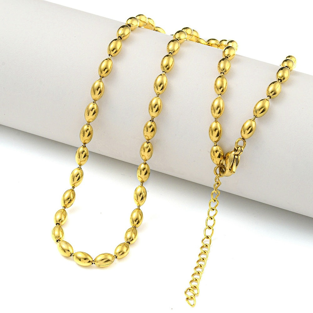 golden oval ball link necklace with lobster claw clasp and extender chain draped over white cylinder form on white surface 