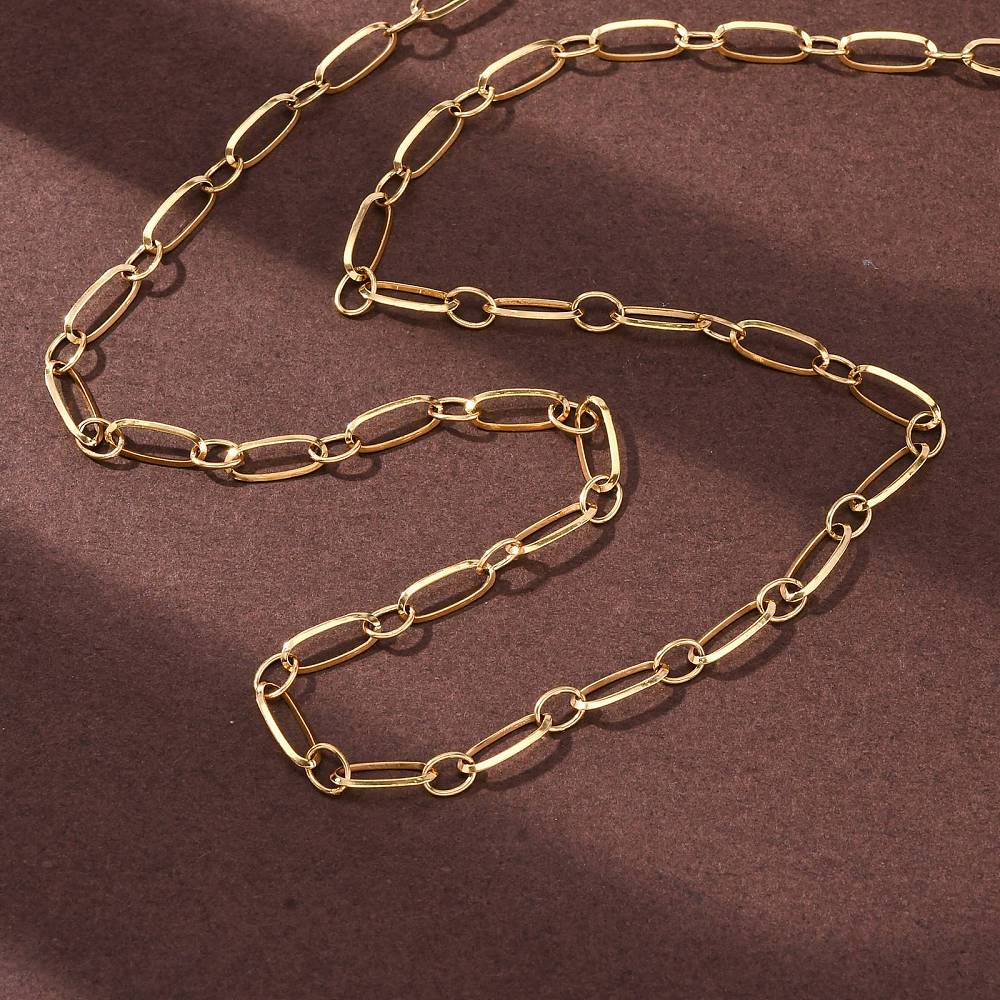 golden alternating oval link chain necklace over brown felt surface. 