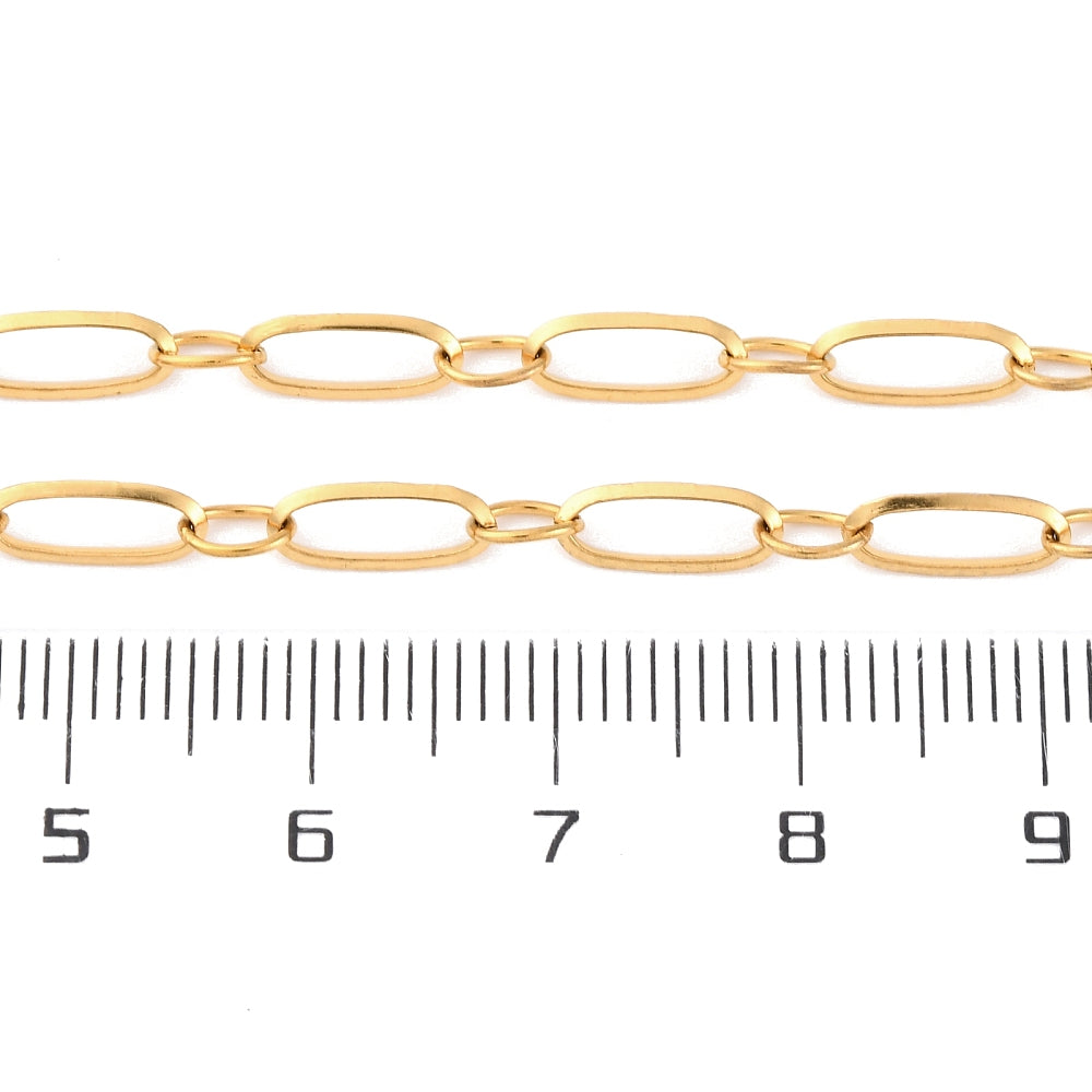 zoomed in sections of golden alternating oval link chain above ruler over white background. 