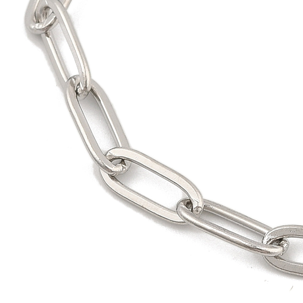 close-up of silver tone paperclip chain bracelet over white background. 