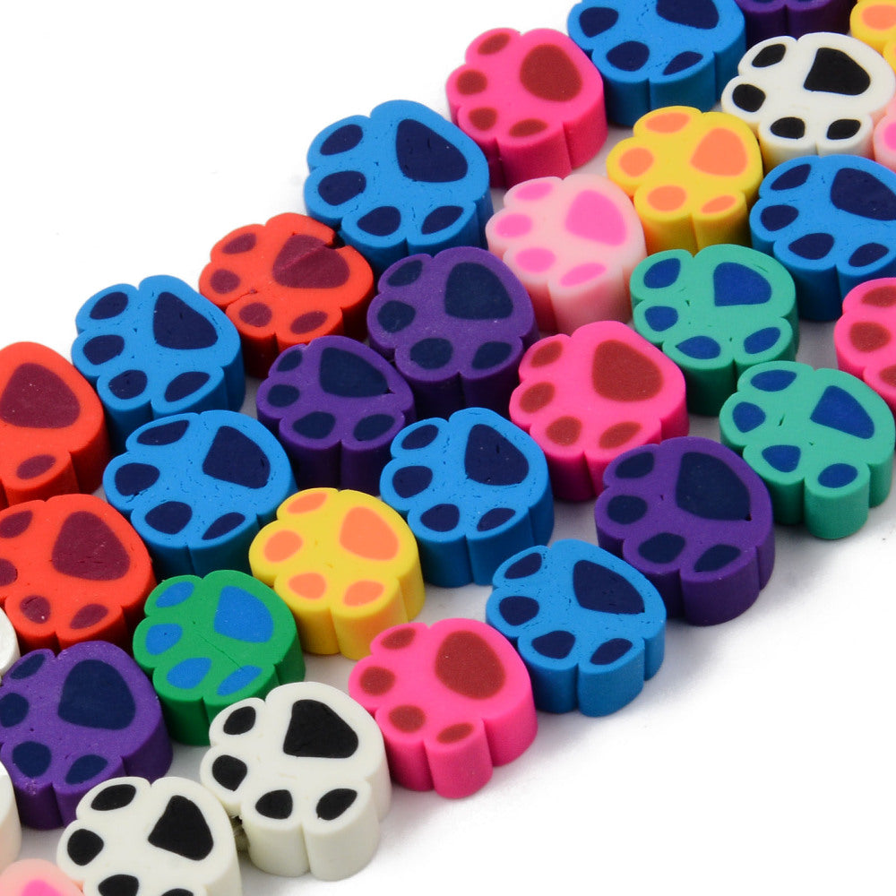 zoomed in sections of colorful handmade polymer clay animal paw print bead strands over white background. 