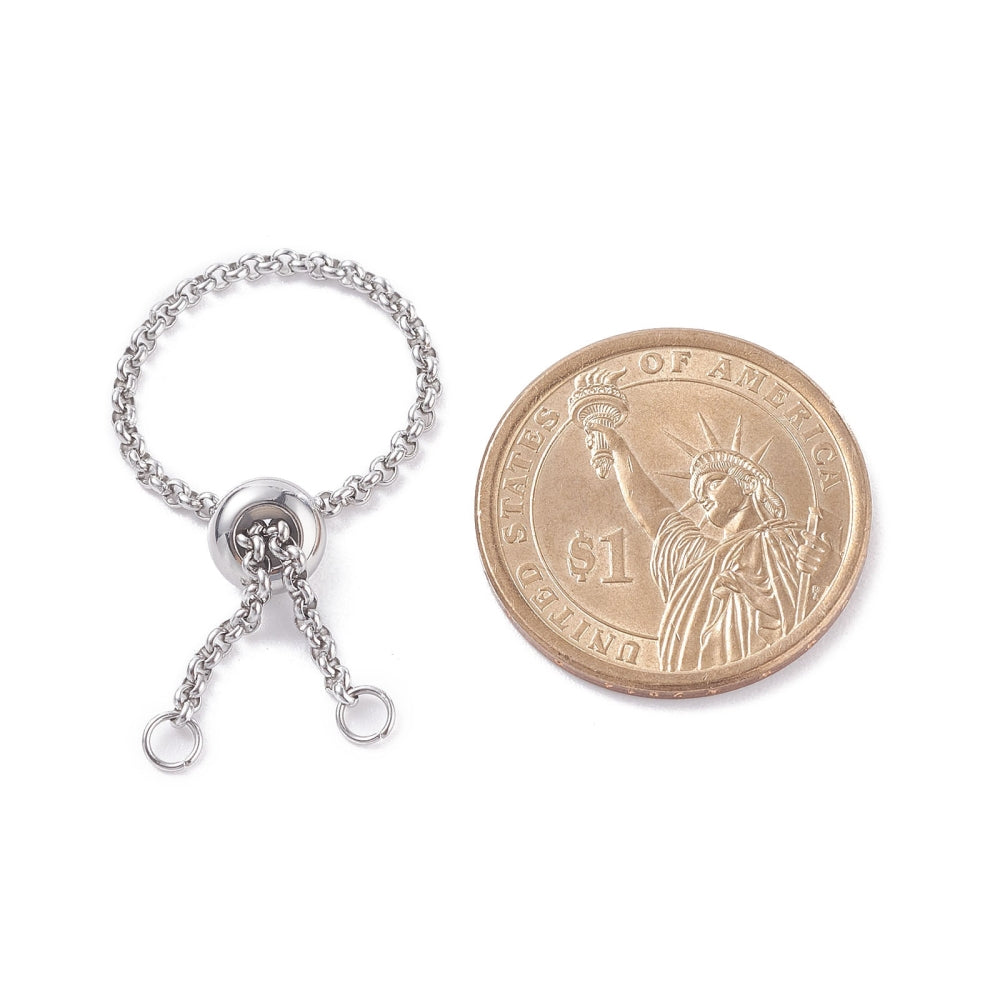 silver tone adjustable fidget ring with Rolo chain and slider bead and two jump rings next to dollar coin over white background. 