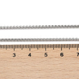 silver tone Venetian box chain displayed above a wooden ruler on white background. 