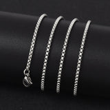 silver tone Venetian box chain with lobster claw clasp wrapped around a black cylinder on black background.  