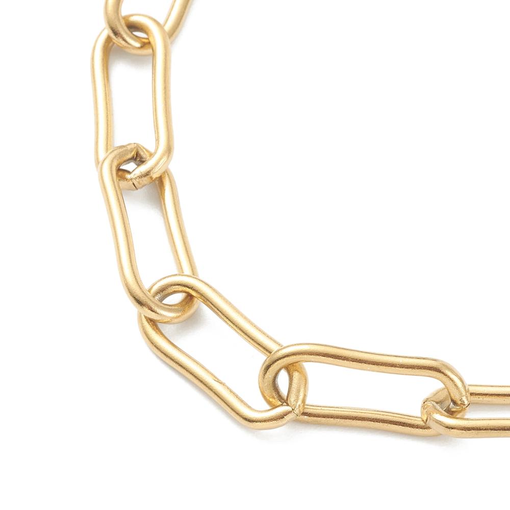 zoomed in section of golden large round paperclip chain over white background.